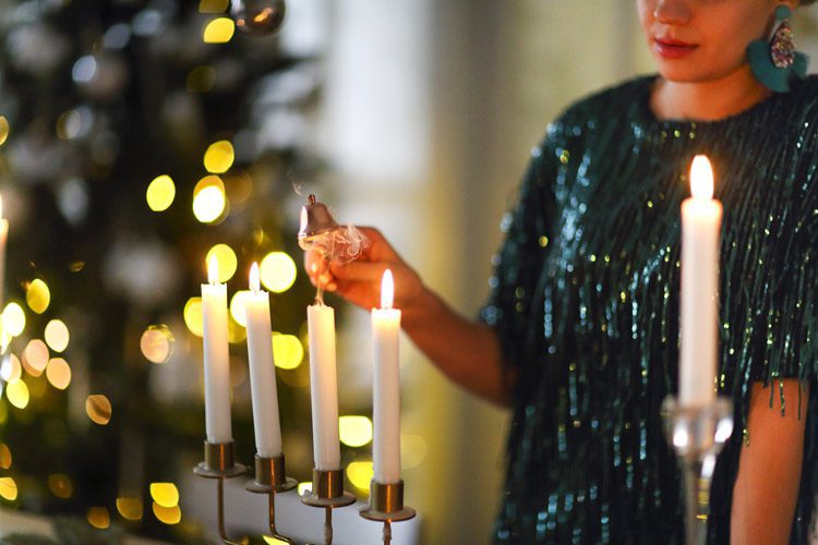cropped shot of beautiful woman dressed in lovely evening wear extinguishing white candles after a holiday party - mental health