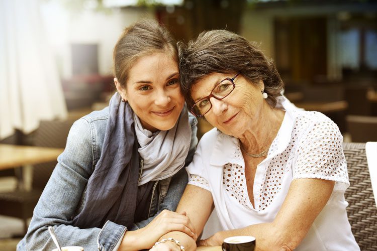 adult woman with her senior mother posing close together - dementia