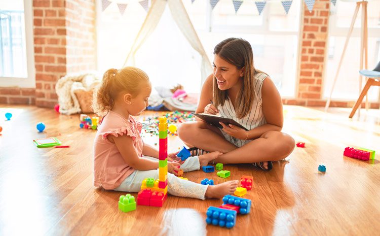 beautiful therapist in Play Therapy session with little girl - doing blocks