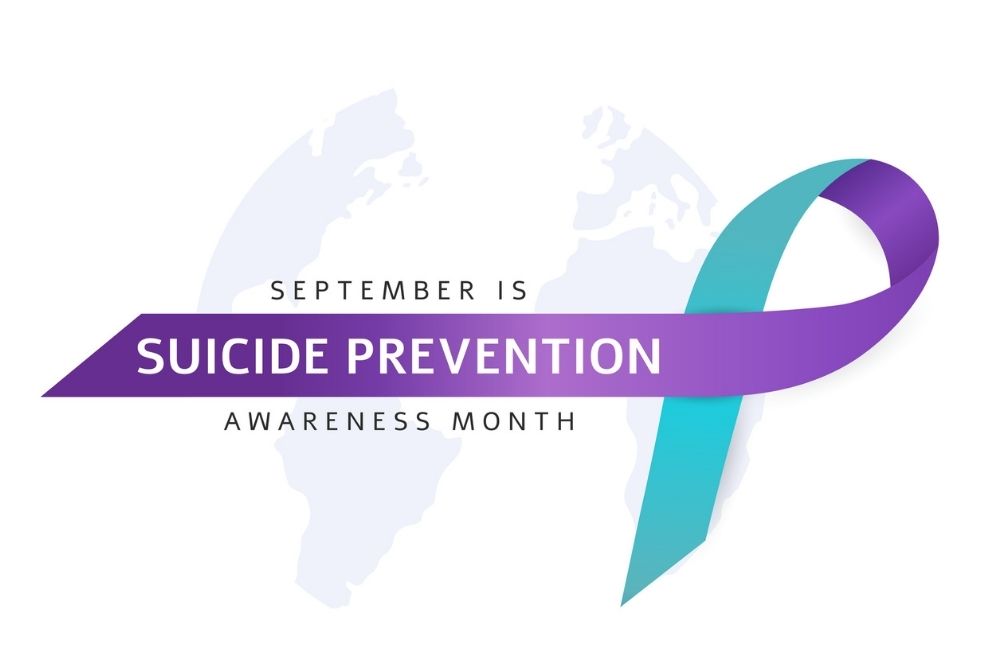 Purple and teal ribbon with the words “September is Suicide Prevention Awareness Month,” symbolizing hope and advocacy for suicide prevention.