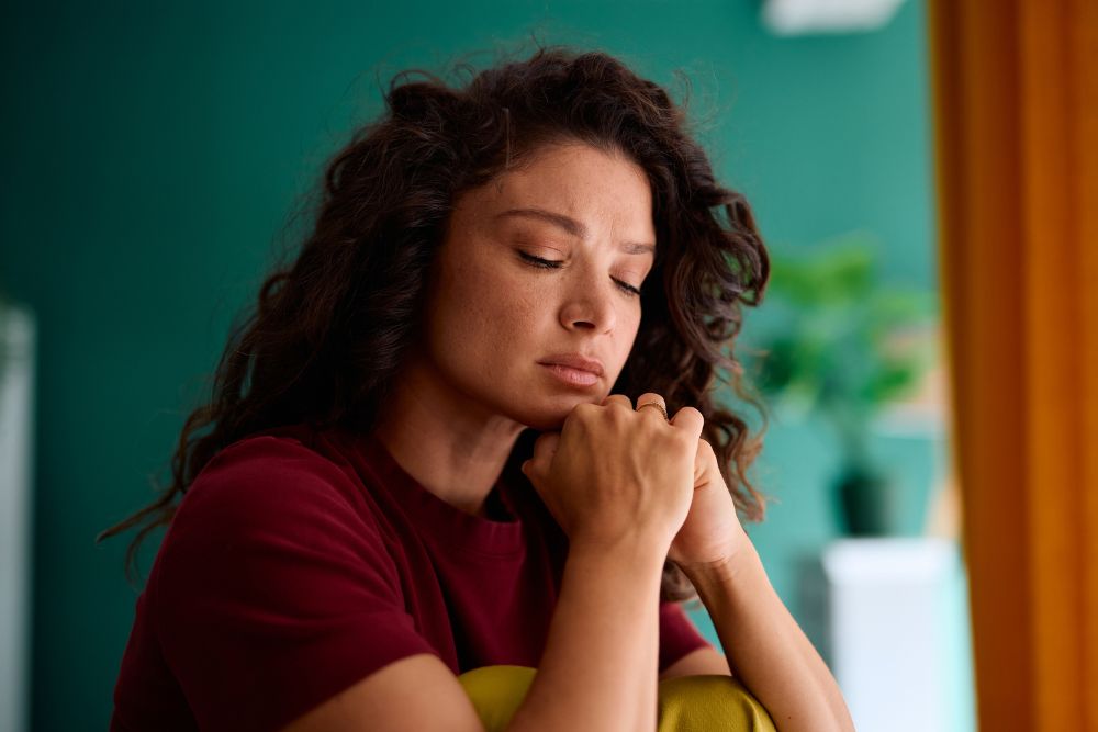 Highland Hospital - 5 Facts About Depression. A woman sits with her eye closed looking upset.